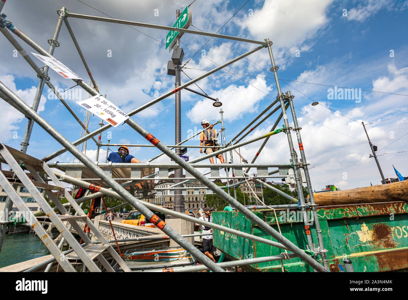 Un equipaggio di tre operai che monta una struttura di impalcatura in via Limmatquai a Zurigo, Svizzera Foto Stock