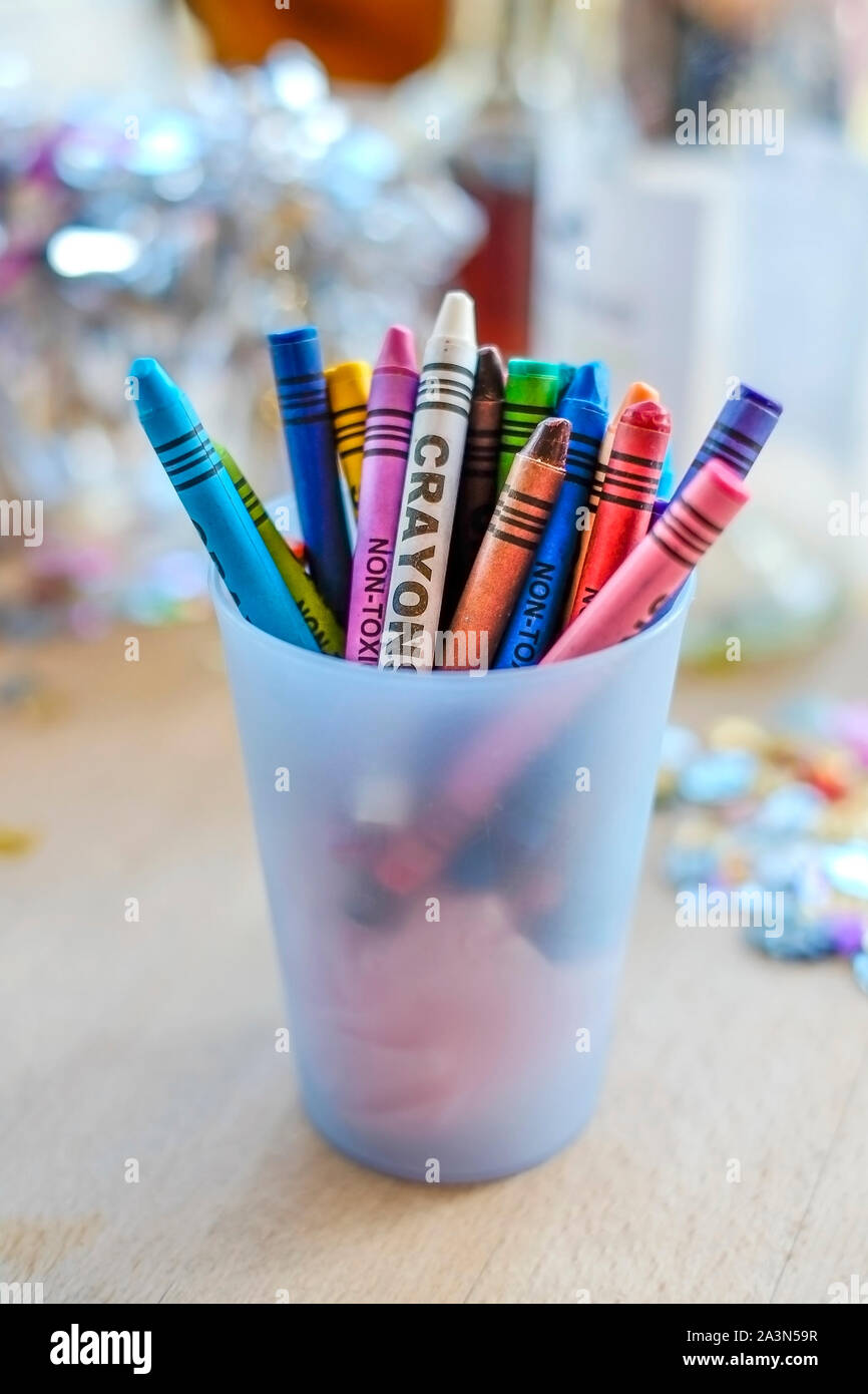 Un vaso in materia plastica piena di pastelli a cera. Foto Stock