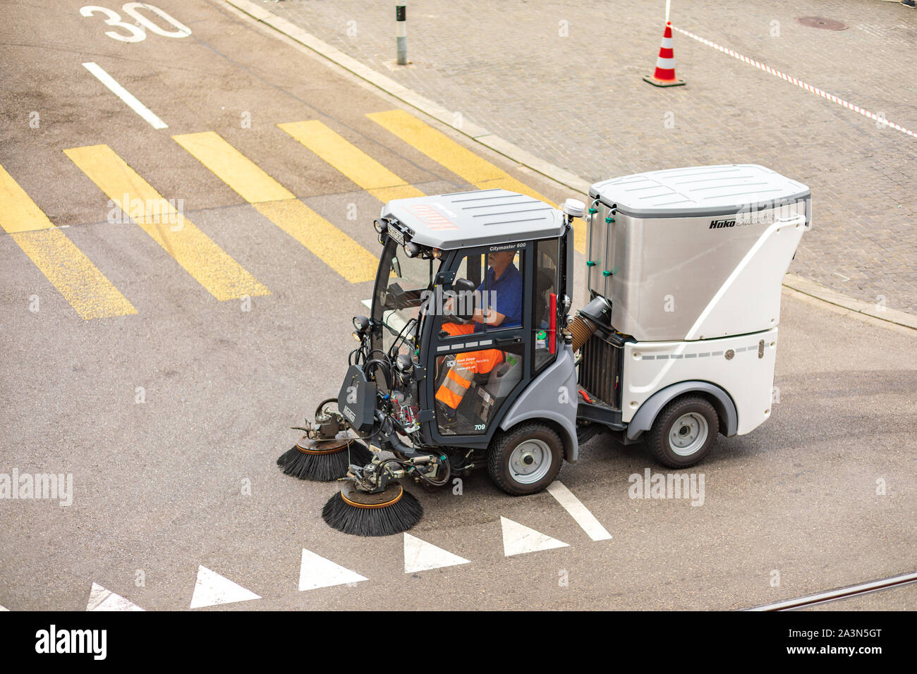 Una piccola spazzatrice stradale compatta Hako pulisce la strada a Zurigo, Svizzera Foto Stock