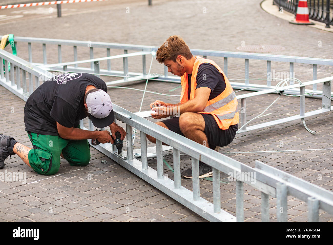 Operai che assemblano una struttura metallica all'aperto in una strada a Zurigo, Svizzera Foto Stock