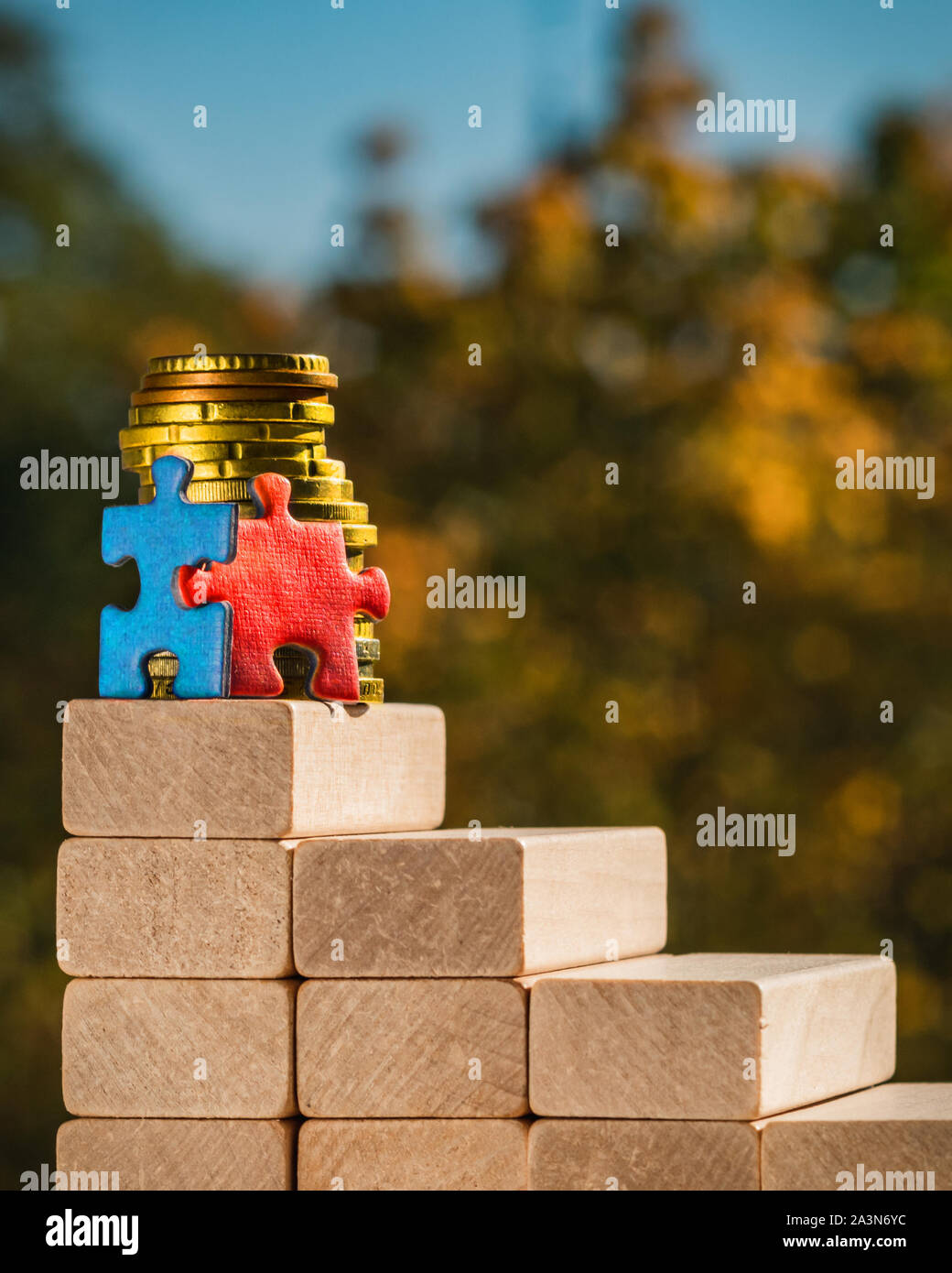 Concetto di lavoro di squadra. Il concetto di vittoria. Due puzzle stand in cima alle scale fatto di blocchi su un autunno sfocata sullo sfondo di una giornata di sole. Foto Stock