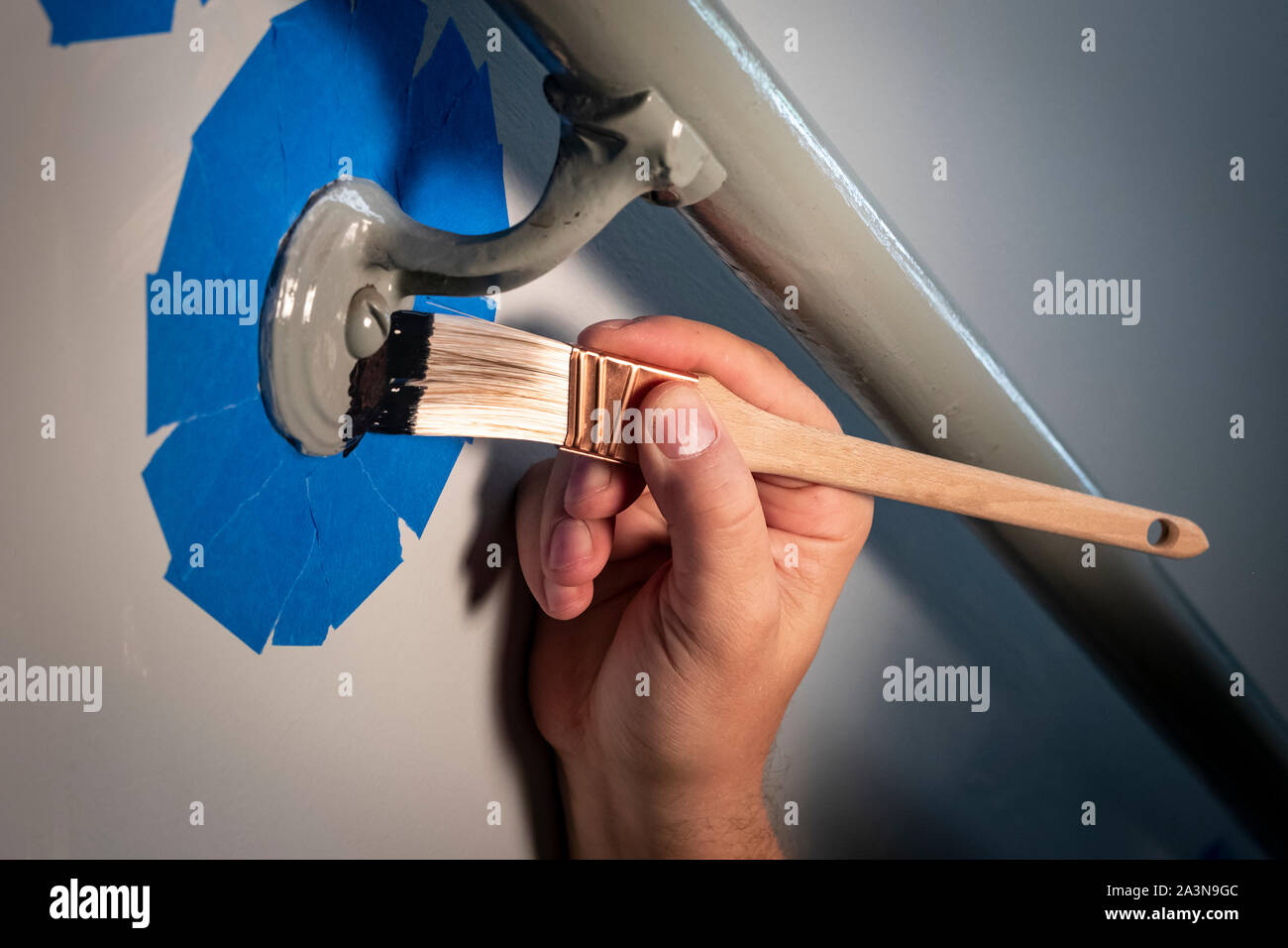 Pittura a mano metallo mancorrente lavoro di vernice preped con pittore nastro Foto Stock