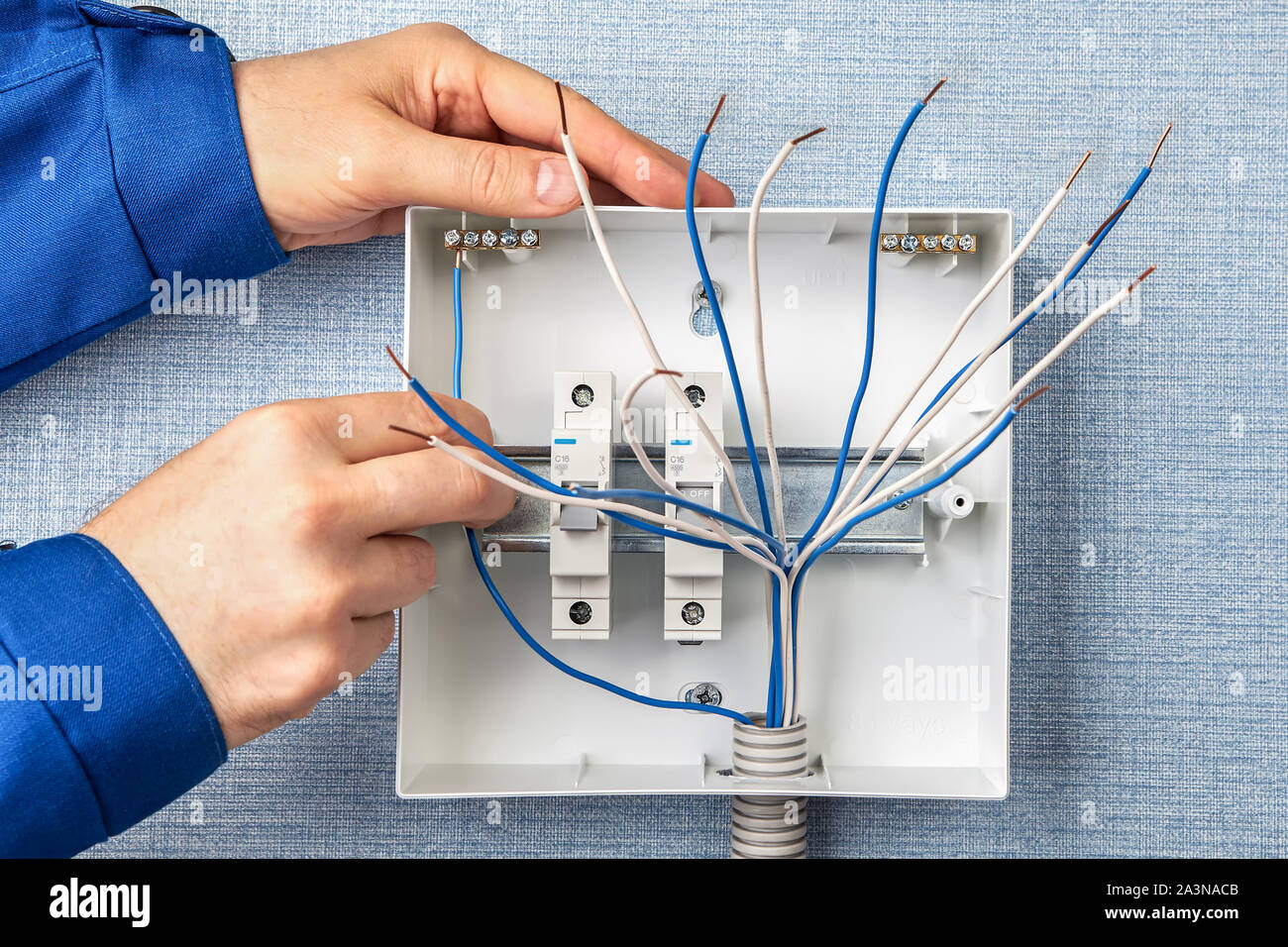 Il tecnico di installazione di un nuovo quadro con fusibili automatici per uso domestico di un cablaggio elettrico. L'installazione di scatole di fusibili in un edificio residenziale, un Foto Stock