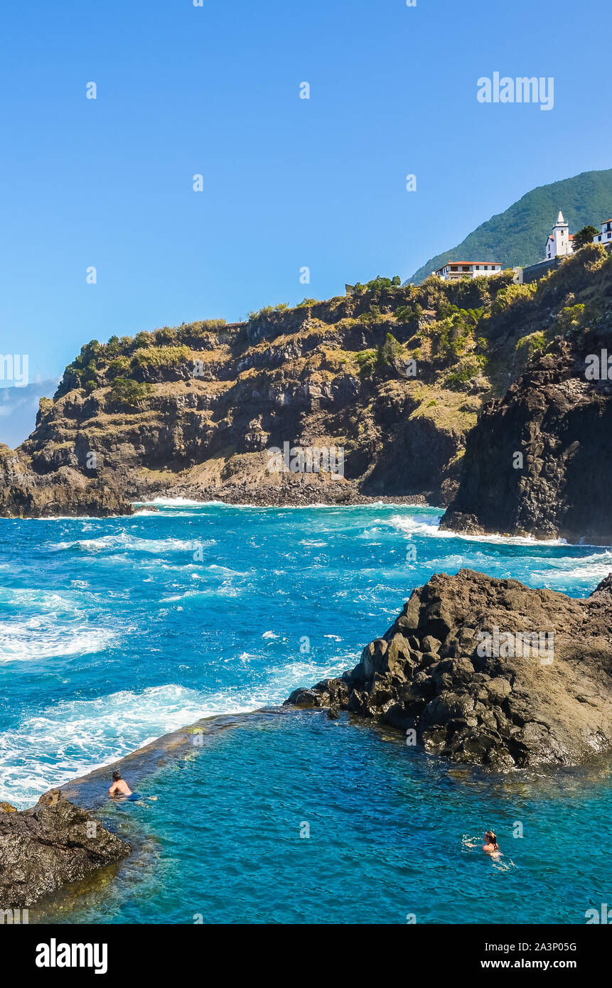 Seixal, Madeira, Portogallo - Sep 13, 2019: paio di nuoto in una piscina naturale nell'Oceano Atlantico. Pool di roccia vulcanica, nel quale il mare fluisce naturalmente. Attrazioni turistiche. Foto Stock