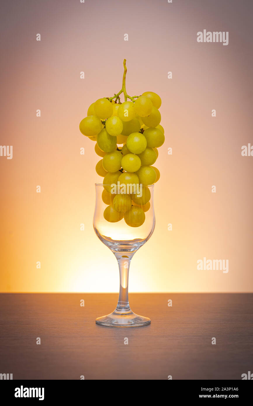 Idea concettuale delle uve in vino vetro come materia prima al posto del prodotto finale Foto Stock