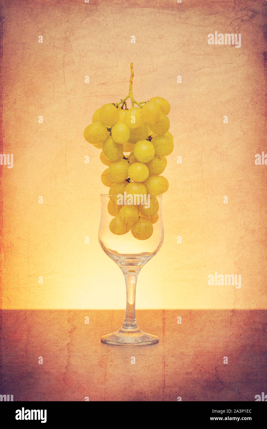 Idea concettuale delle uve in vino vetro come materia prima al posto del prodotto finale utilizzando il filtro retrò Foto Stock