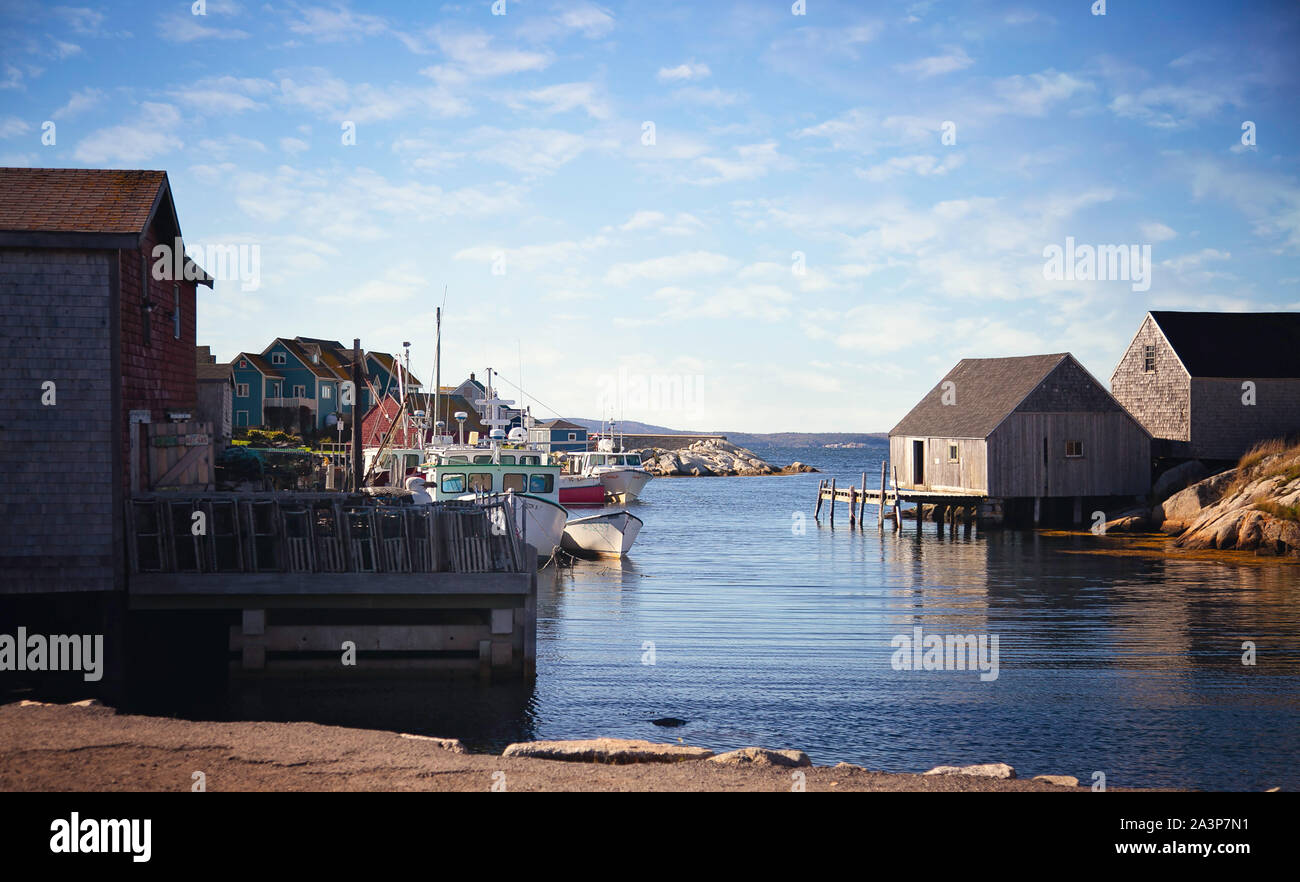 Barche da pesca e colorati shacks fiancheggiano le banchine nella storica Peggy's Cove, Nuova Scozia, Canada Foto Stock