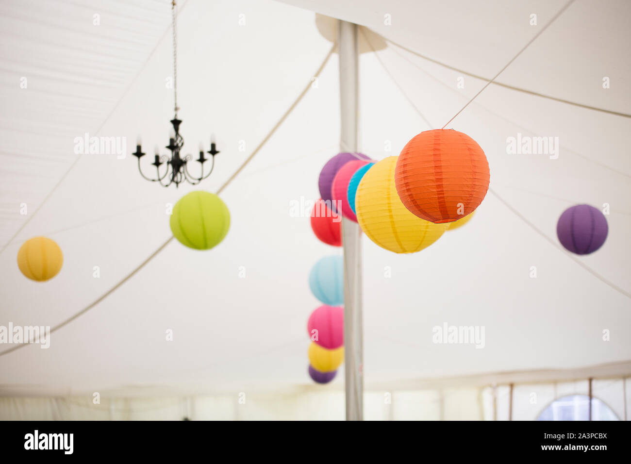 Colorate lanterne di carta appeso lungo il soffitto del ricevimento di nozze tenda Foto Stock