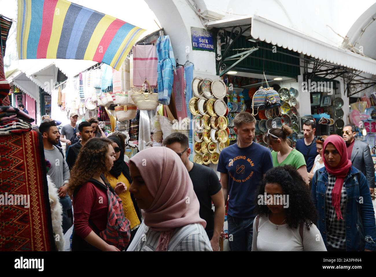 Una folla di turisti stranieri a piedi passato negozi di souvenir nel souk della Kasbah quartiere della Medina (città vecchia) di Tunisi, Tunisia. Foto Stock