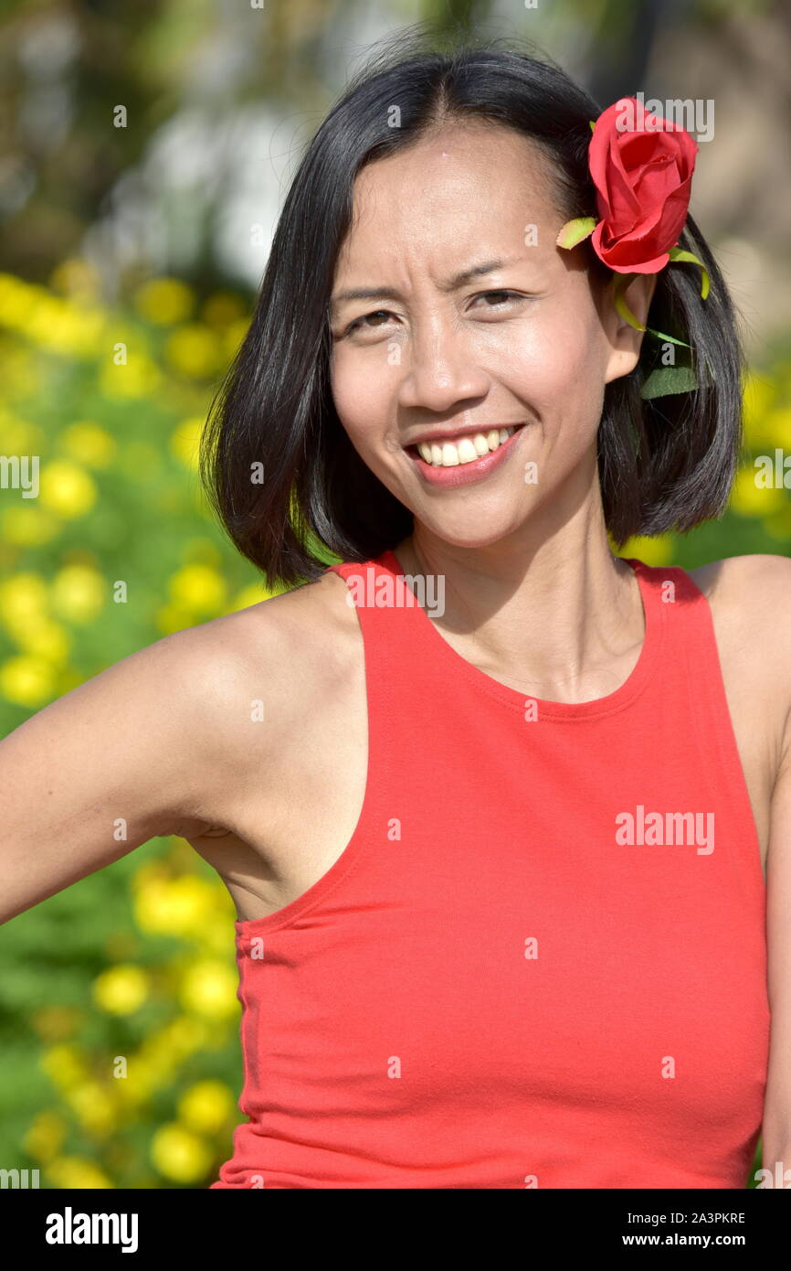 Felice piuttosto Filipina donna femmina con una rosa Foto Stock