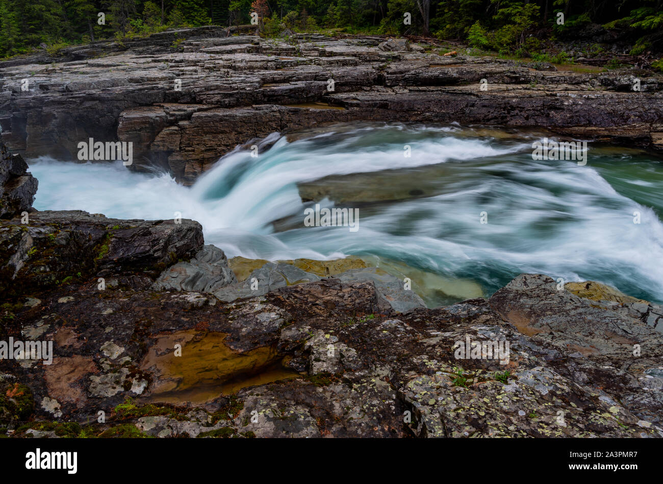 Correre sulla neve in fusione Montana di fiume con una lunga esposizione Foto Stock