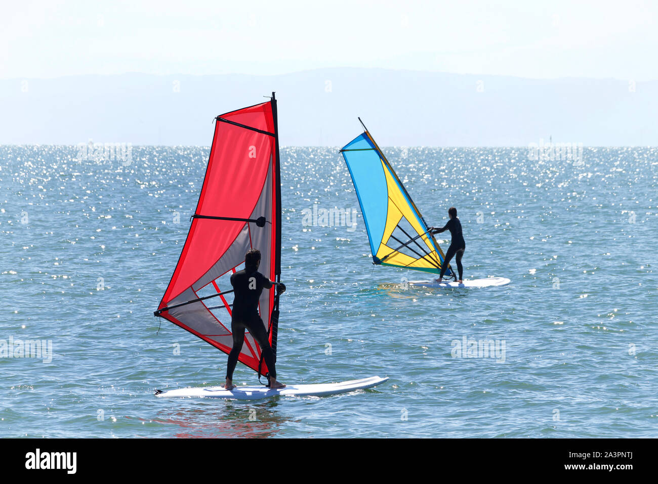 Persone di imparare a windsurf fuori dell'isola Alameda nella Baia di San Francisco. Windsurf una superficie sport d'acqua che combina elementi di navigazione e Foto Stock