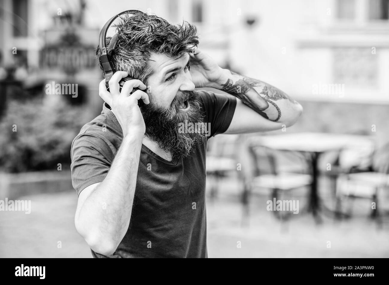 Hipster godere di un suono di ottima canzone in auricolari. Camminare con la musica. Musica per energico l'umore. Ritmo per camminare. Uomo Barbuto hipster ascolto in cuffia la musica. Ottima musica playlist. Foto Stock