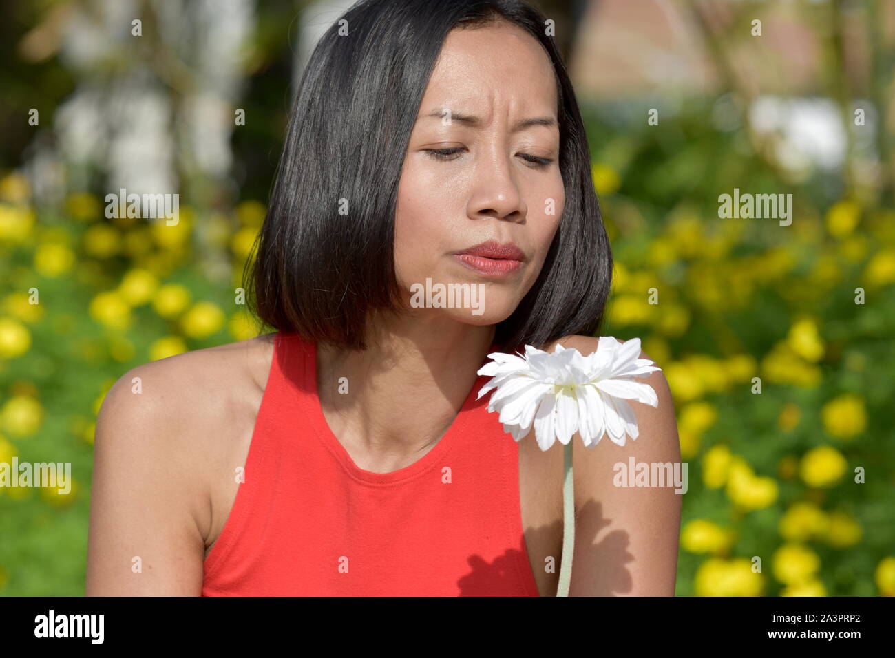 Grave minoranza giovane femmina adulta con un fiore Foto Stock