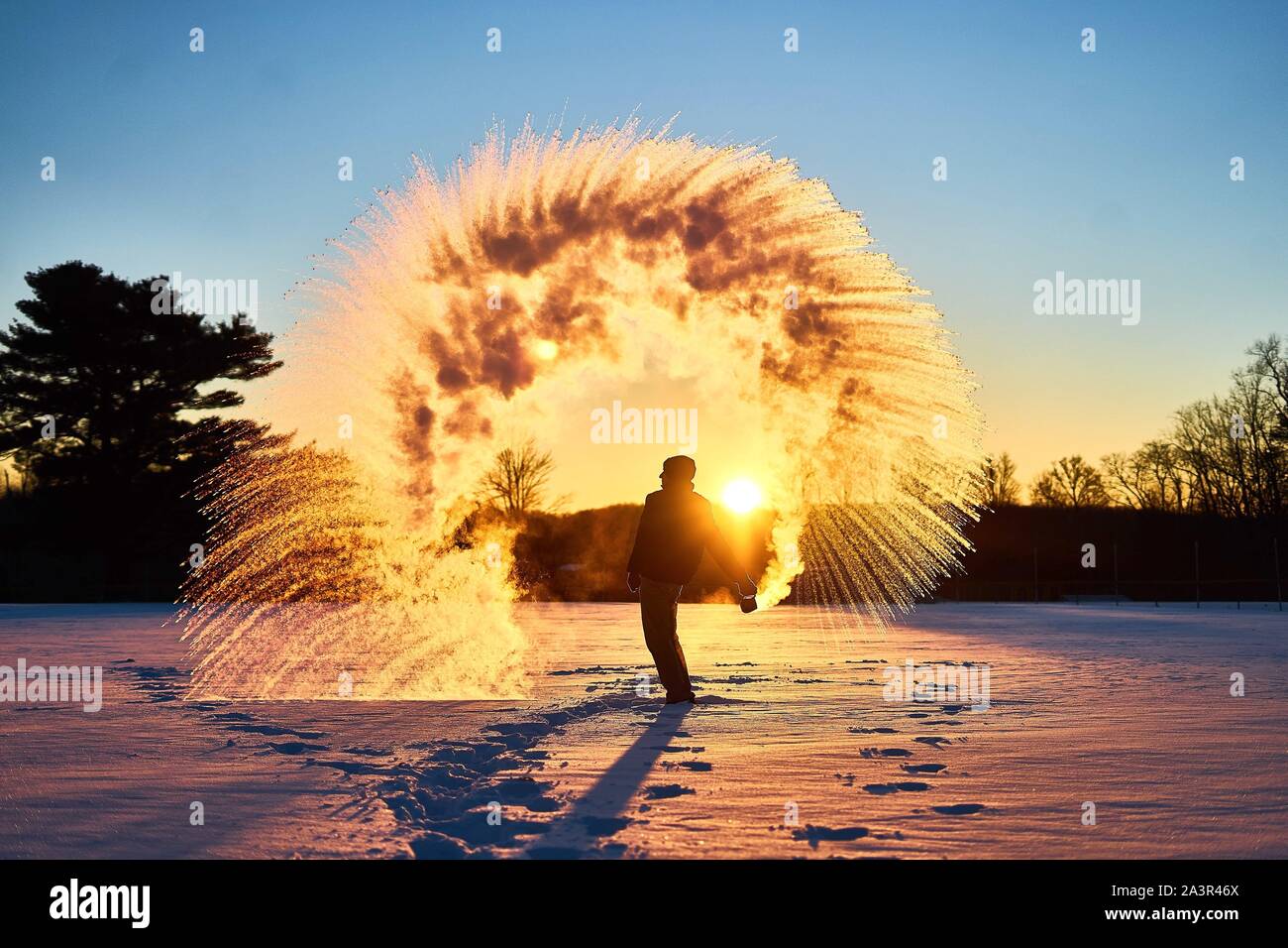 Uomo di gettare acqua bollente in aria di congelamento Foto Stock