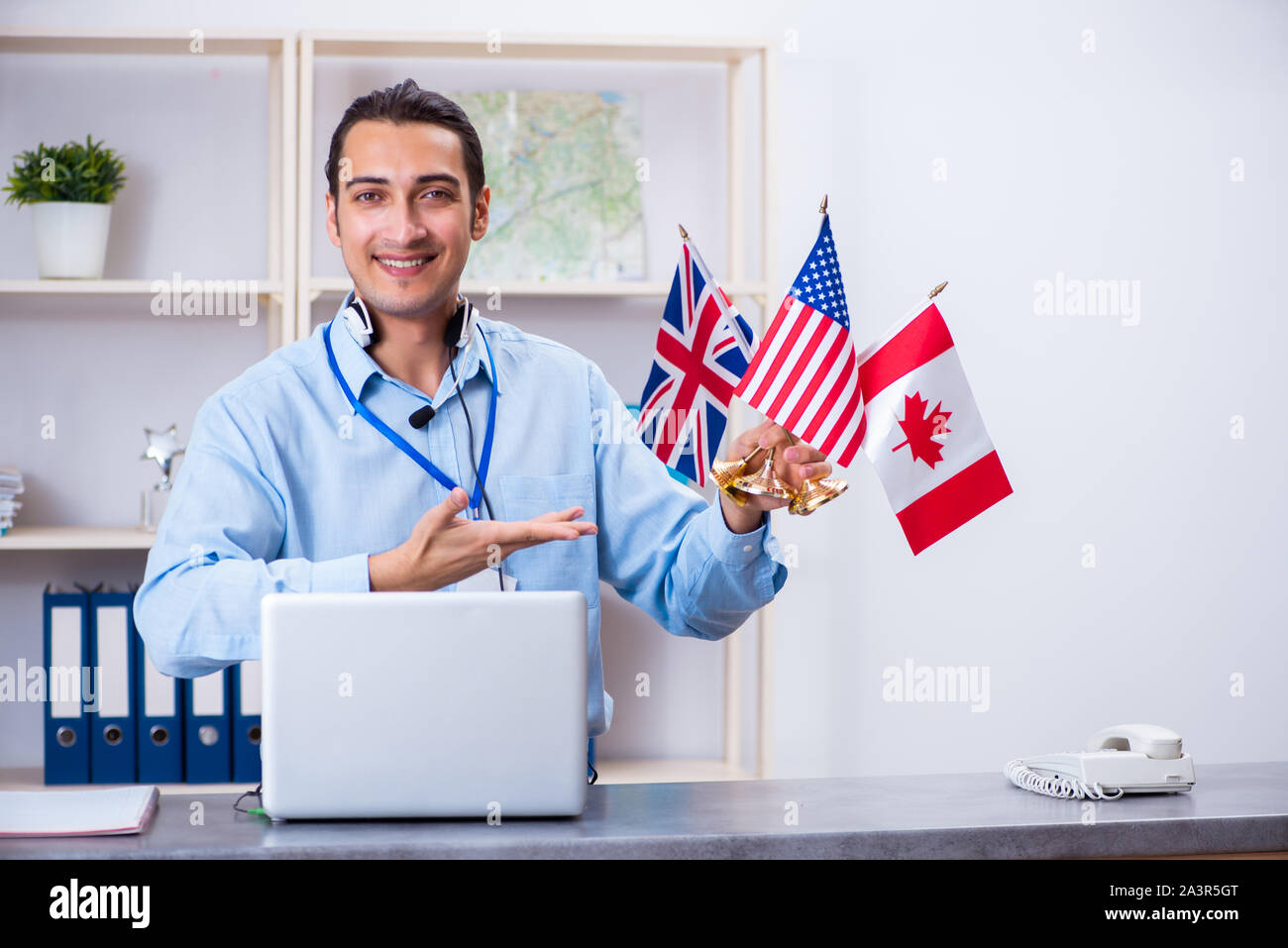 Il giovane maschio agente di viaggio lavora in ufficio Foto Stock