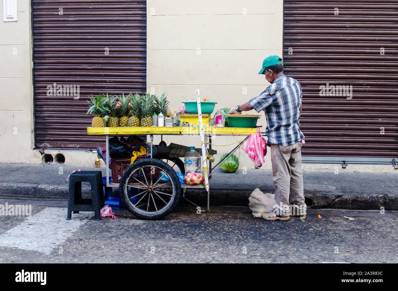 Venditore ambulante di vendita frutta fresca su un marciapiede in città murata di Cartagena Foto Stock