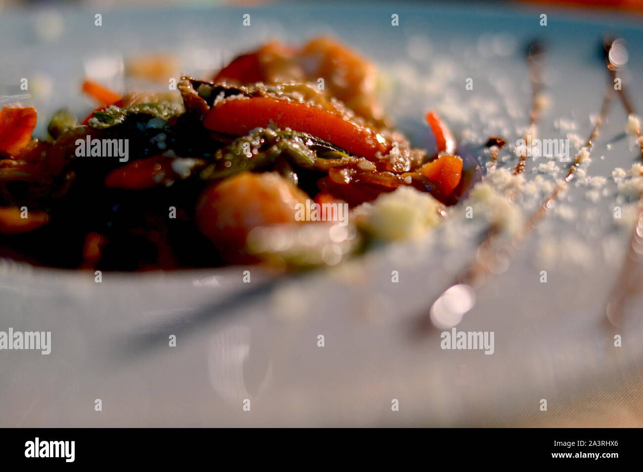 MANZO AL PEPERONCINO dolce con parmigiano cosparso in una ciotola bianca. Foto Stock