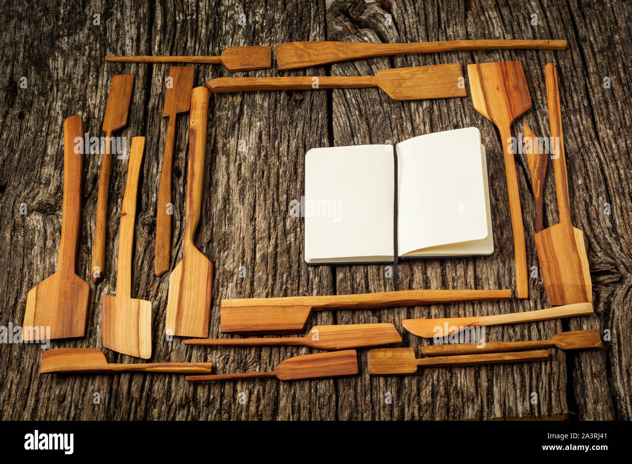 Cornice fatta di utensili da cucina in un casale rustico tavolo da cucina con notebook. Foto Stock