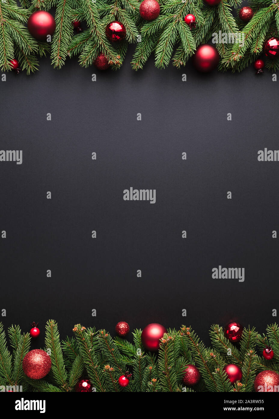 Natale o Capodanno sfondo. Cornice decorativa cornice di rami di abeti e palle di Natale su sfondo nero Foto Stock