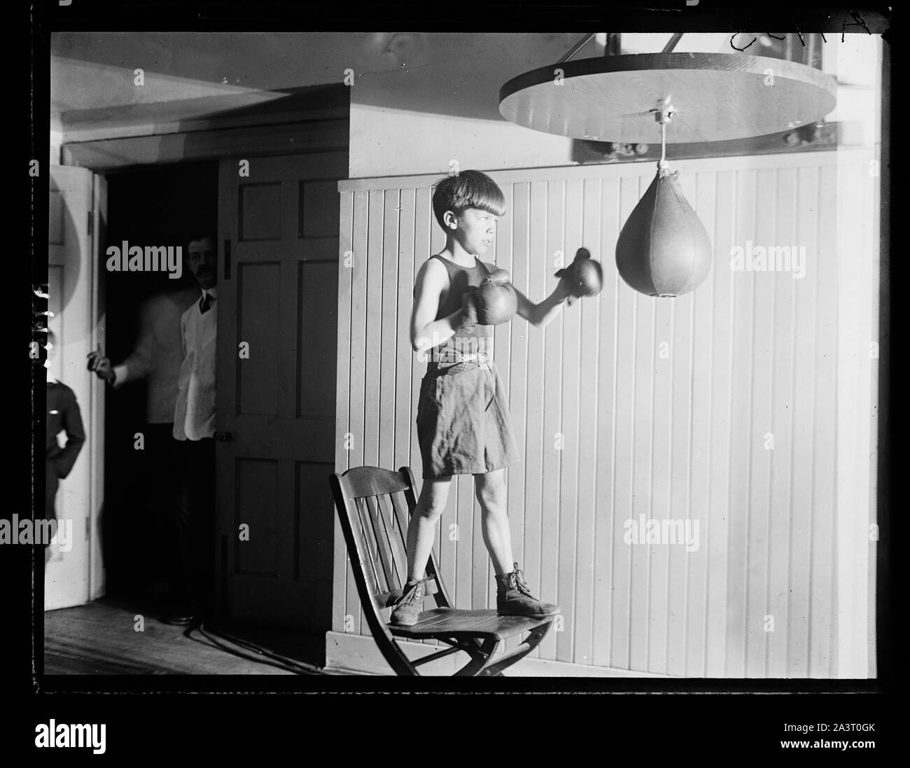 Teddy Roosevelt, Jr., figlio dell'Asst. Secy. della Marina, punzonatura il sacco presso la palestra al Racquet Club Foto Stock
