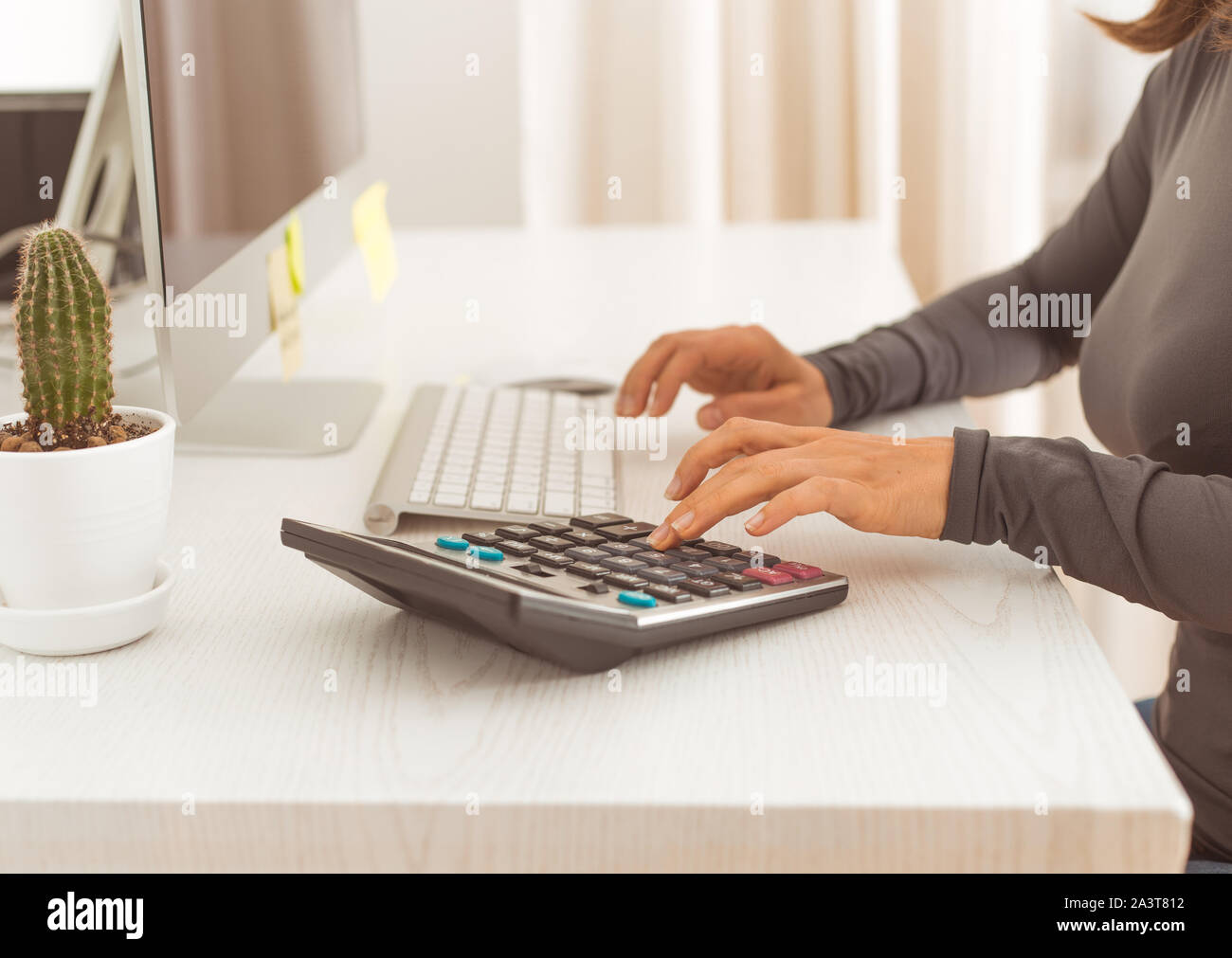 Il commercialista lavora su una calcolatrice. Il finanziere scrive una dichiarazione dei redditi. Uomo d'affari sul posto di lavoro. Foto Stock