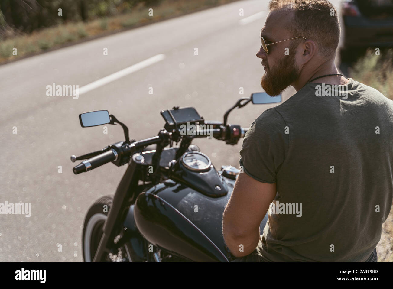 Vista posteriore di un barbuto biker seduto su una motocicletta Foto Stock