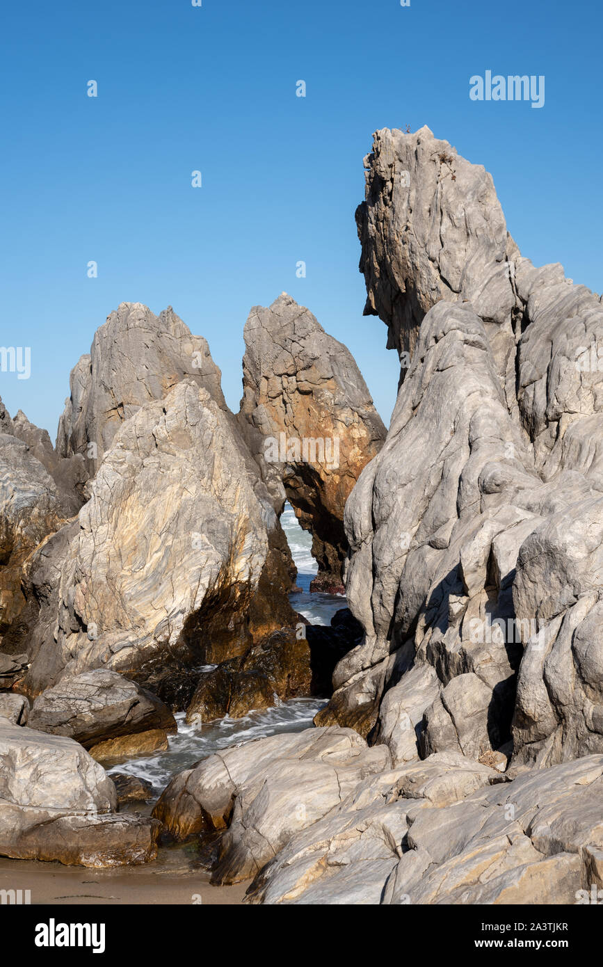 Un cielo blu senza nuvole e mare rocce di varie forme. Foto Stock