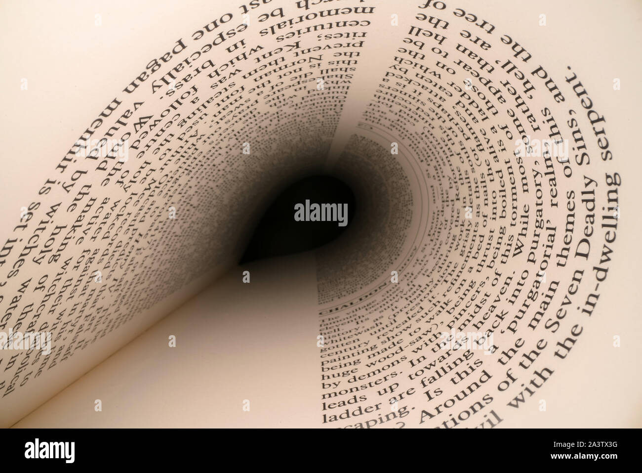 All'interno del libro concetto. Lettere Latine e parole su una a forma di tunnel, prospettiva pagina del libro con nero luce drammatica. Istruzione, del concetto di conoscenza Foto Stock