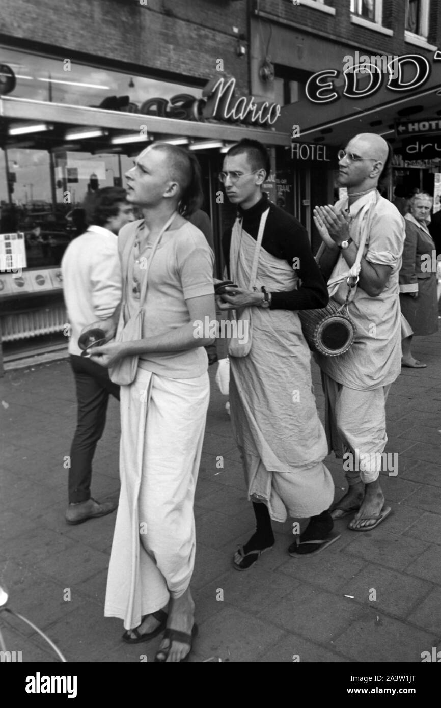 Singend, lobpreisend und trommelnd bewegen sich Hare Krishna Jünger durch die strassen von Amsterdam Niederlande 1971. Il canto, lodando e drumming Hare Krisha seguaci dancing attraverso le strade di Amsterdam, Paesi Bassi 1971. Foto Stock