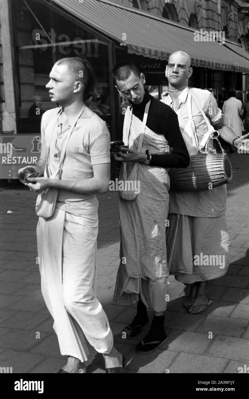 Singend, lobpreisend und trommelnd bewegen sich Hare Krishna Jünger durch die strassen von Amsterdam Niederlande 1971. Il canto, lodando e drumming Hare Krisha seguaci dancing attraverso le strade di Amsterdam, Paesi Bassi 1971. Foto Stock