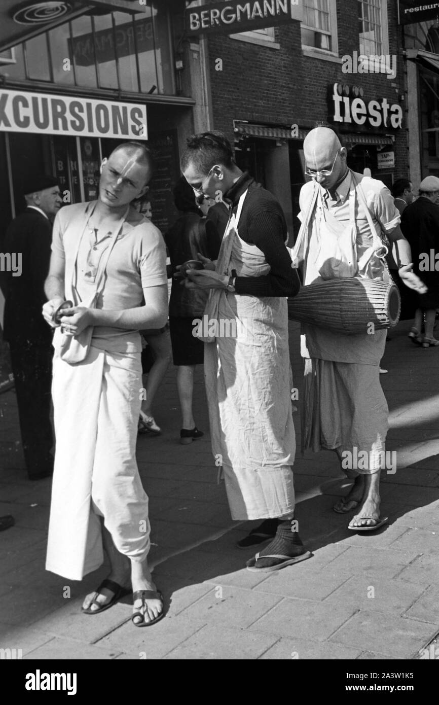 Singend, lobpreisend und trommelnd bewegen sich Hare Krishna Jünger durch die strassen von Amsterdam Niederlande 1971. Il canto, lodando e drumming Hare Krisha seguaci dancing attraverso le strade di Amsterdam, Paesi Bassi 1971. Foto Stock