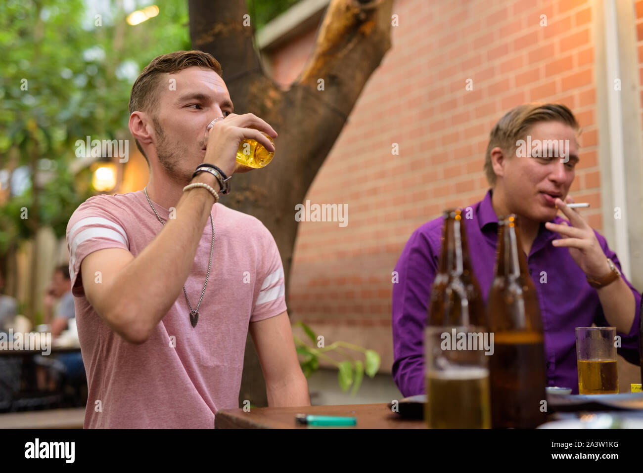 Uomo felice di parlare e di bere birra con gli amici Foto Stock