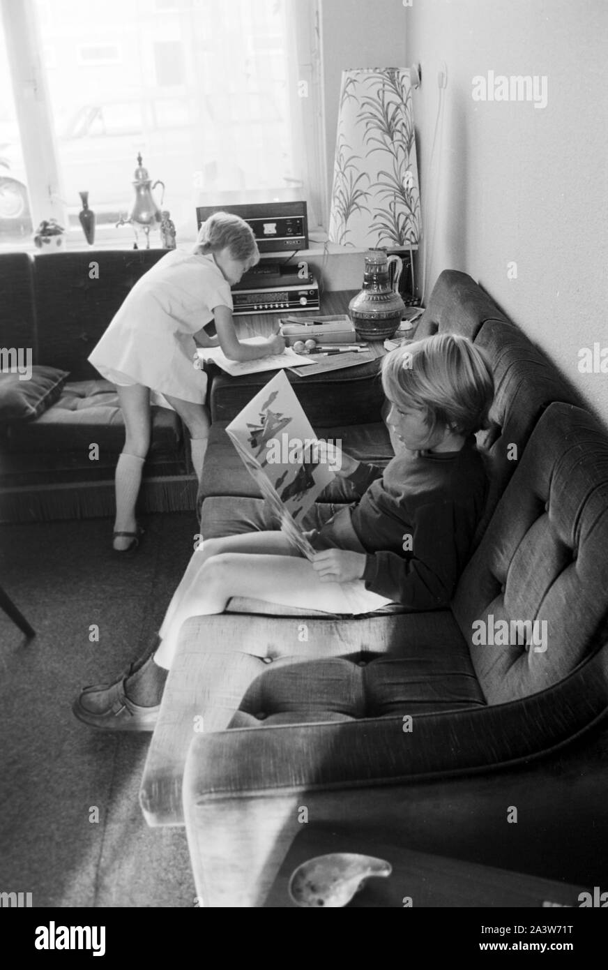 Kinder beschäftigen sich im Wohnzimmer, Deutschland frühe 1970er Jahre. I bambini presso il salotto, la Germania nei primi anni settanta. Foto Stock