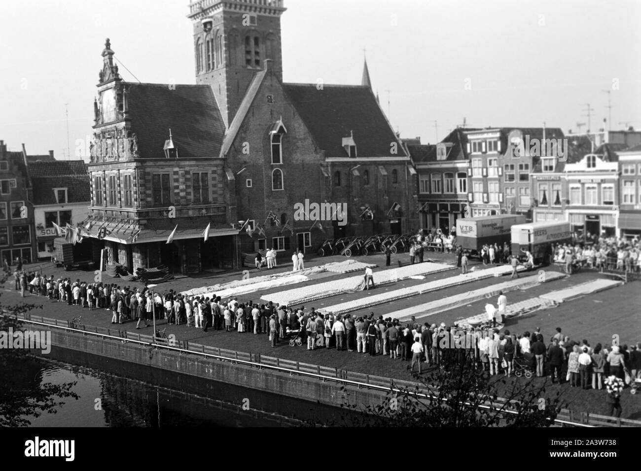 Aufbau zum Käsemarkt vor der Stadtwaage De Waag a Alkmaar, Niederlande 1971. La configurazione del mercato del formaggio di fronte alla città pesare edificio De Waag a Alkmaar, Paesi Bassi 1971. Foto Stock