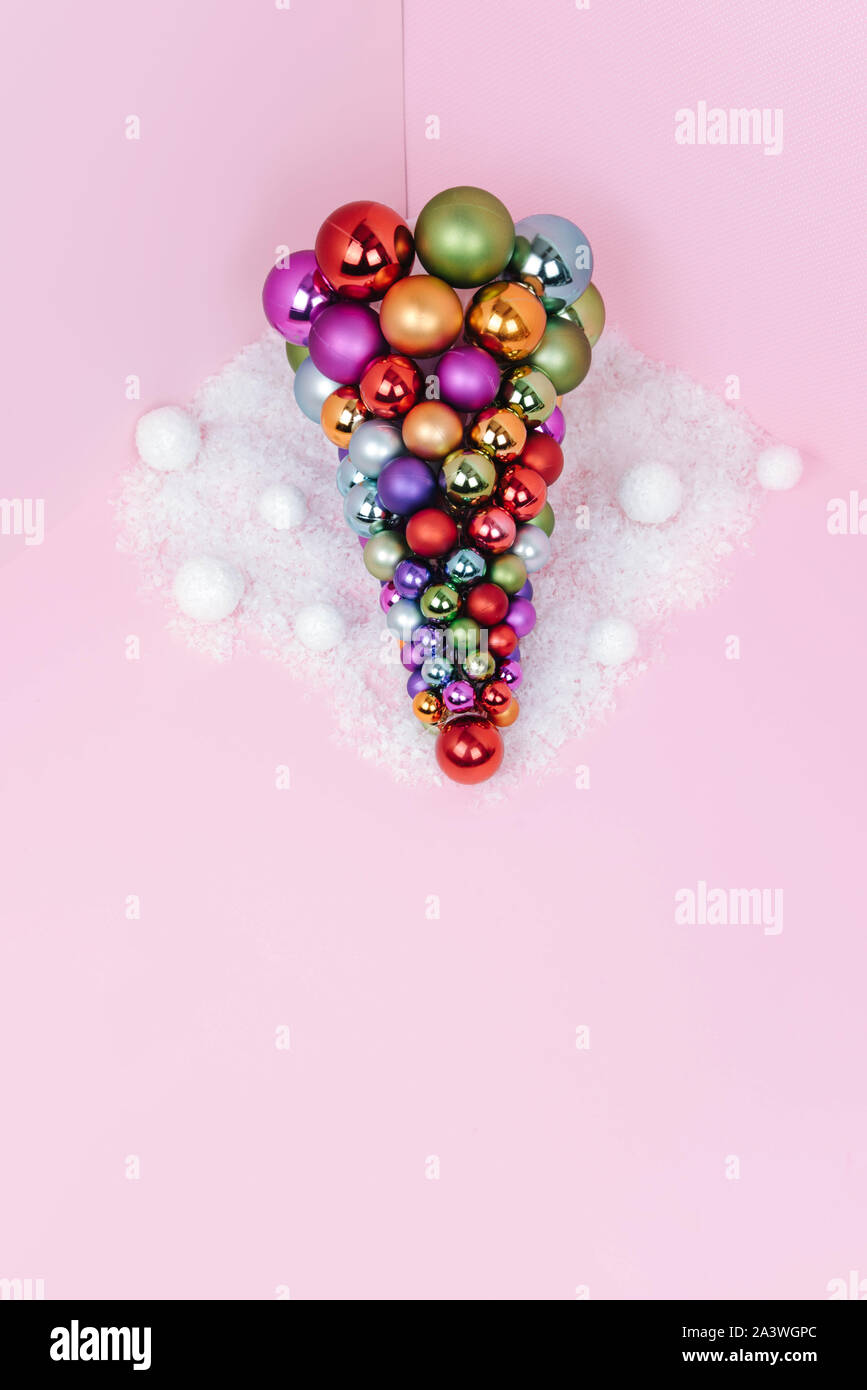 Albero di Natale fatto di decorazione a sfera su sfondo rosa. Foto Stock