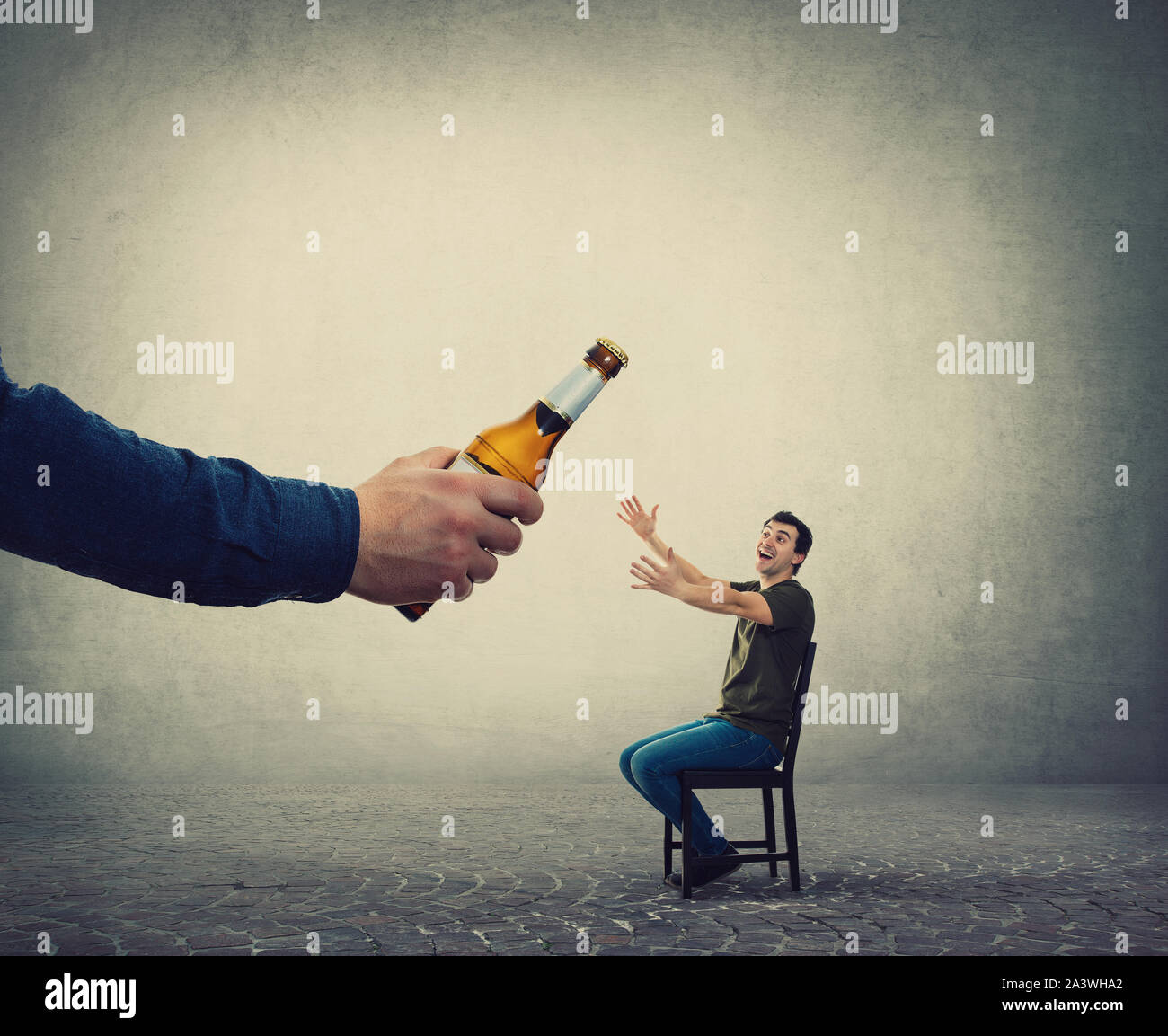 L'alcol addicted uomo, mani tese, ricevendo un enorme bottiglia di birra da una persona sconosciuta mano. Illegale di contrabbando di alcool, propaganda e mark Foto Stock