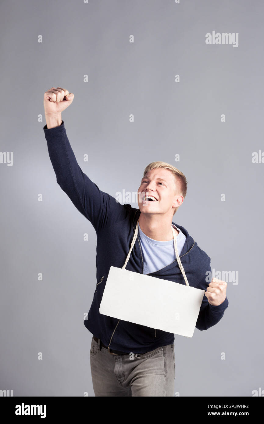 Overjoyed uomo di successo presentando blank cartello. Foto Stock