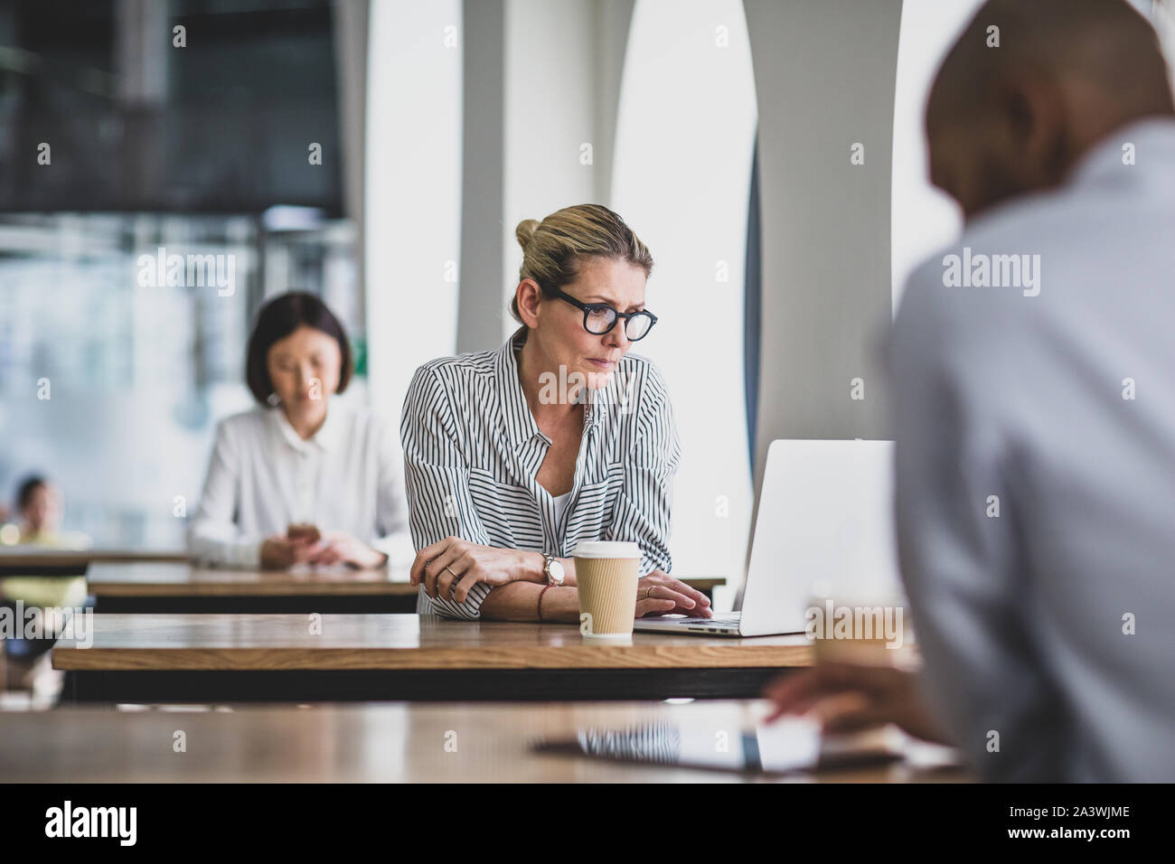 Imprenditrice in un cafÃ© usando un computer portatile Foto Stock