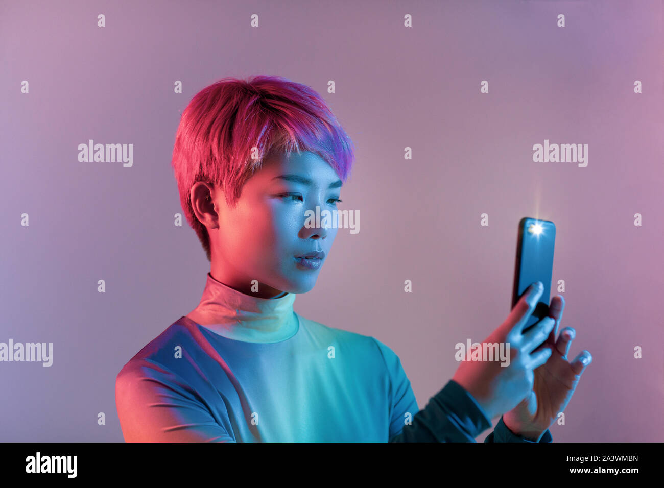 Ripresa creativa del giovane femmina adulta prendendo foto con lo smartphone Foto Stock