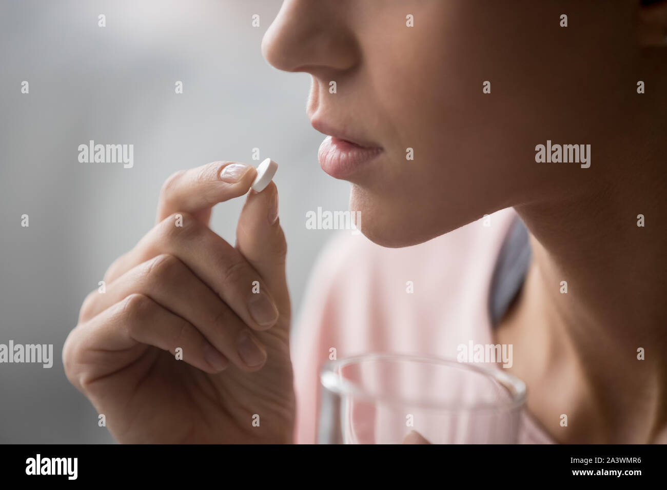 Malata holding pillola bicchiere di acqua, vista ravvicinata Foto Stock