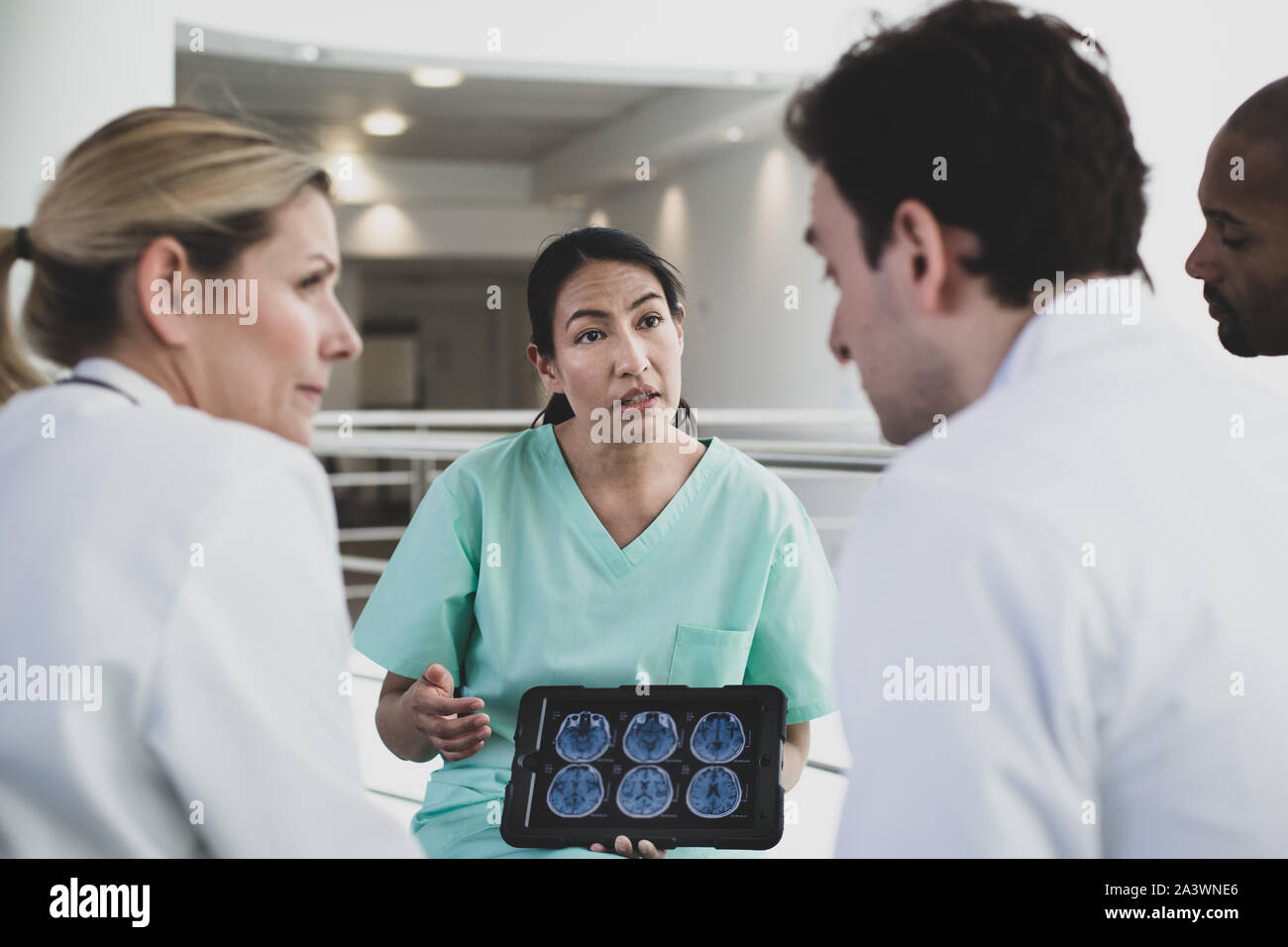 Femmina chirurgo ispanica discutere i risultati in un ospedale Foto Stock