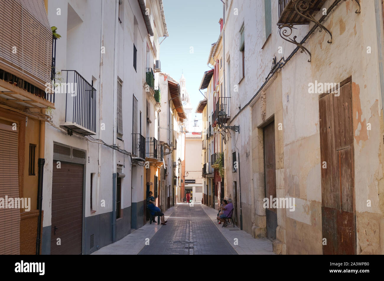 Xativa, Valencia, Spagna - Ottobre, 2019: la gente seduta su strada stretta di Jativa Foto Stock