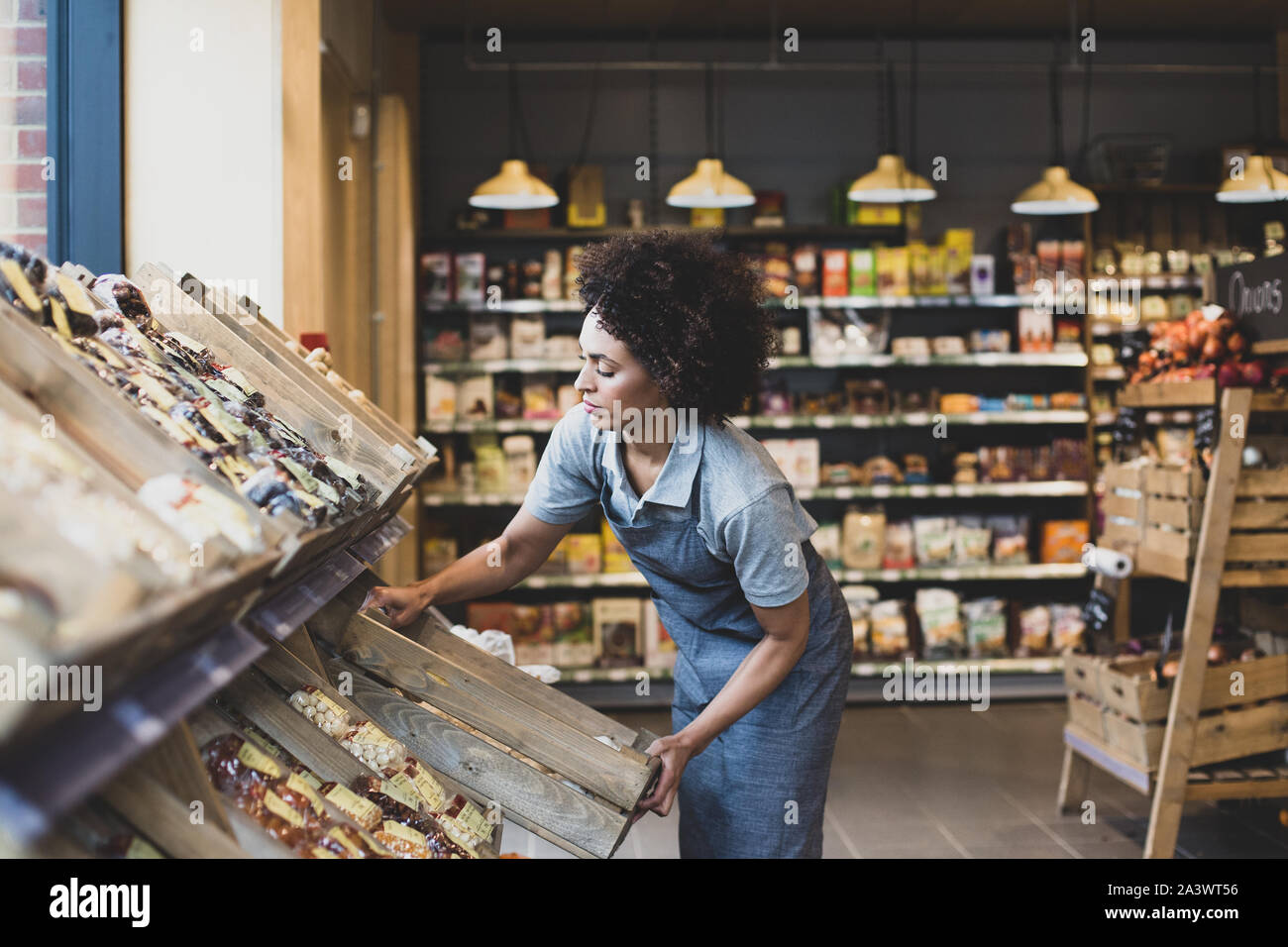 Proprietario di piccola impresa di un mercato alimentare di scaffalature di stoccaggio Foto Stock