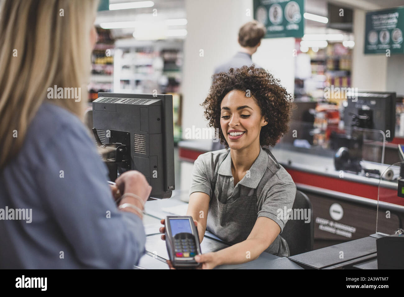 Addetto alle vendite lavora al negozio di alimentari Foto Stock