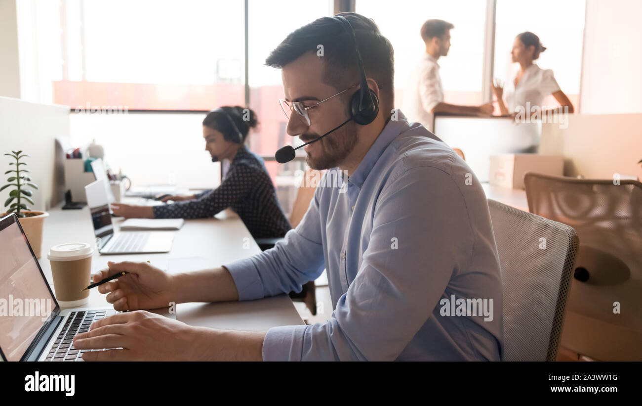 Maschio di agenti del call center utilizzando il computer in ufficio customer care Foto Stock