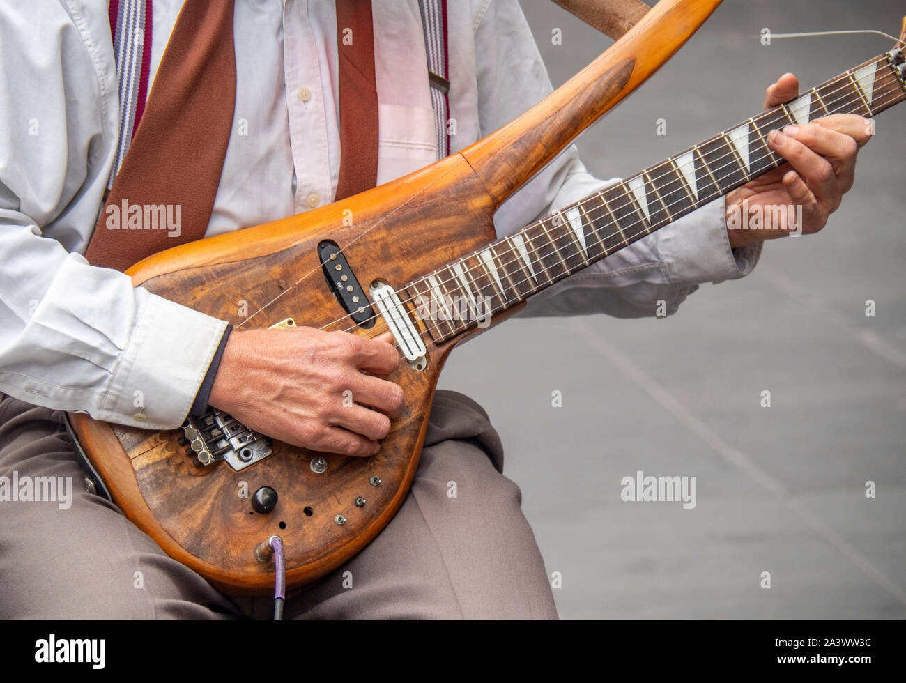 Close up di un suonatore ambulante maschio riproduzione di un corpo solido  di chitarra elettrica Foto stock - Alamy