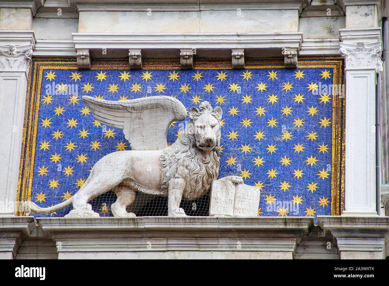 Statua del leone alato sulla torre dell'Orologio di Piazza di San Marco a Venezia, Italia. Leone alato tenendo una Bibbia è il simbolo della città di Venezia. Foto Stock