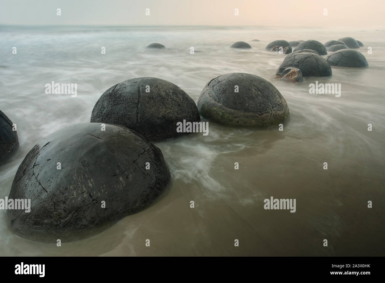 Moeraki Boulders all'alba sulla spiaggia Koekohe, Otago, South Island, in Nuova Zelanda. Foto Stock