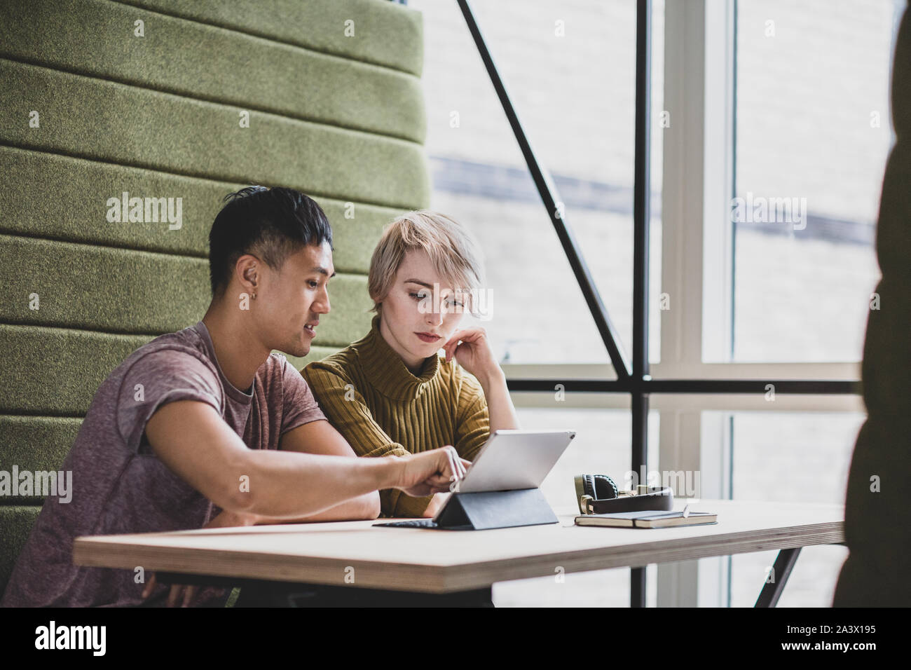 I colleghi di lavoro in occasione di un incontro guardando una tavoletta digitale Foto Stock